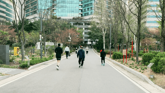 People walking or running in city park with high-rise buildings