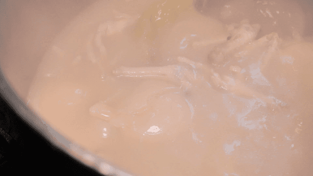 Chicken feet broth boiling with vegetables