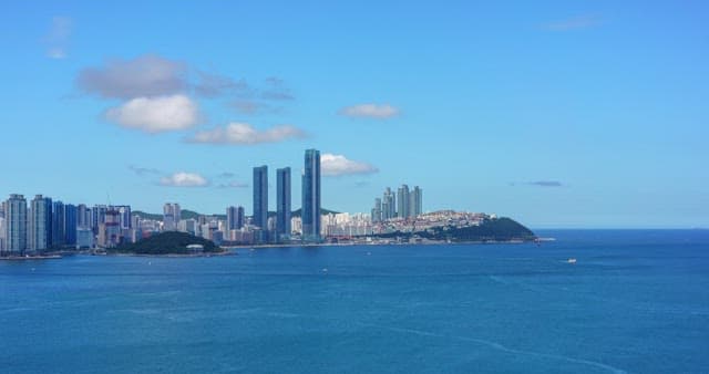 Busan, a modern city with high-rise buildings and calm, blue sea