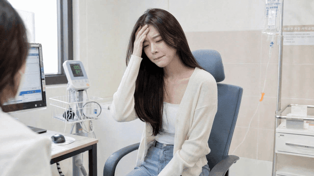 Female patient consulting with doctor at hospital