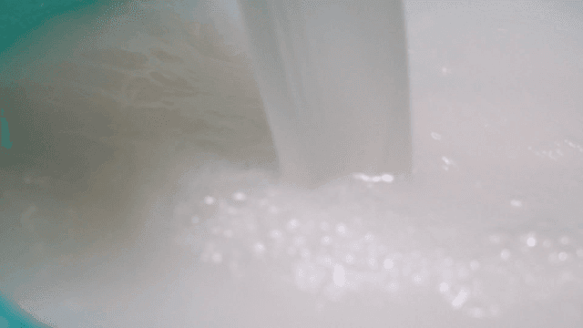 Milky rice water poured into bowl
