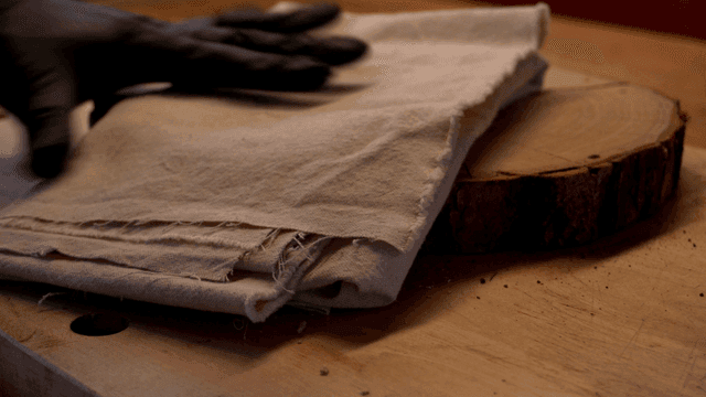 목재 위로 천을 얹고 망치로 치는 장인