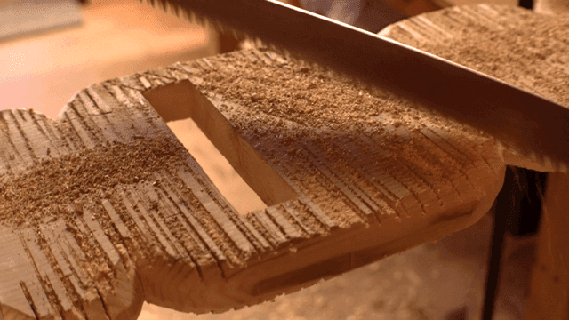 실내에서 톱으로 나무를 자르는 모습