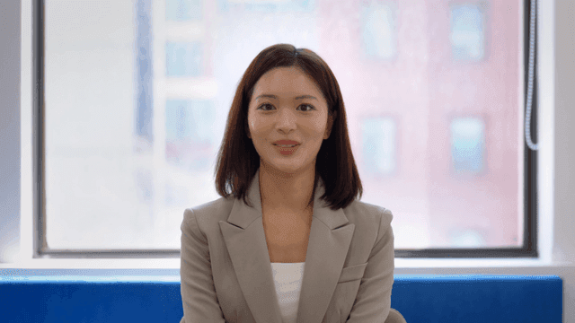 Woman in suit answering with smile at interview