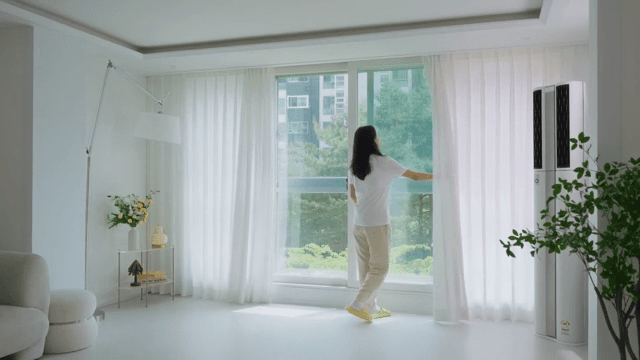 하얀 인테리어의 현대적인 거실 커튼을 여는 여자
