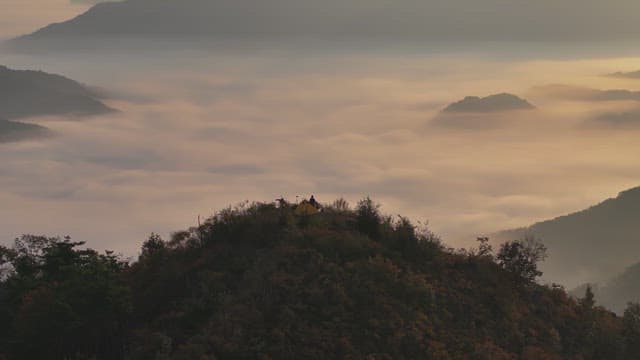 구름 낀 산 꼭대기에서 캠핑하는 모습