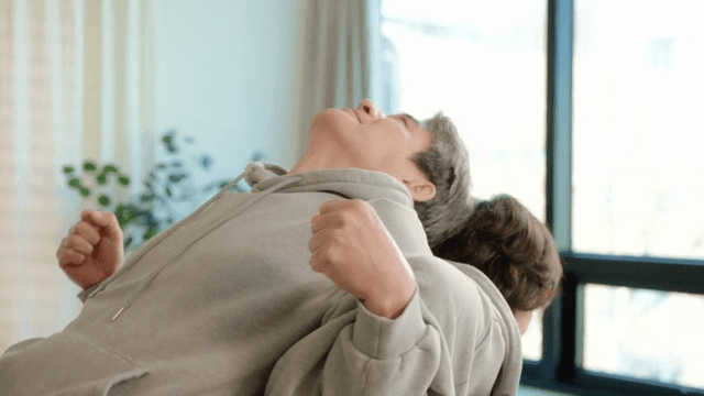 Elderly couple stretching in the living room