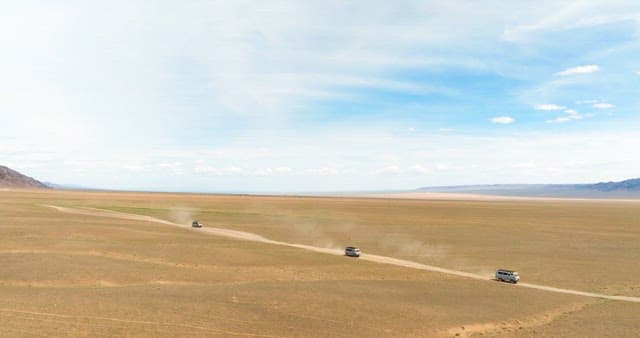 Vans driving through a vast desert landscape