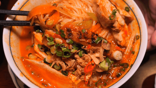 Chopsticks for mixing spicy rice noodles decorated with toppings