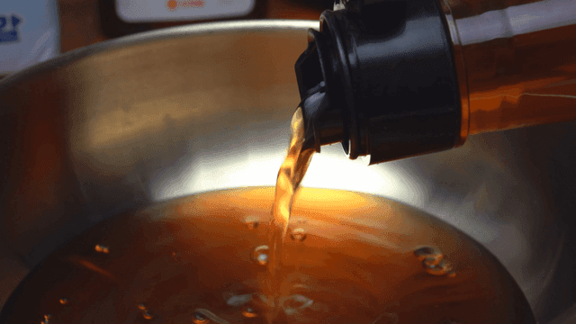 금속 그릇에 멸치액젓을 붓는 장면