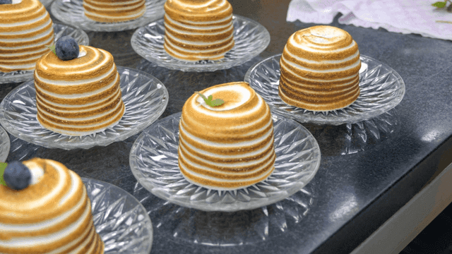 Chef decorating desserts with blueberries
