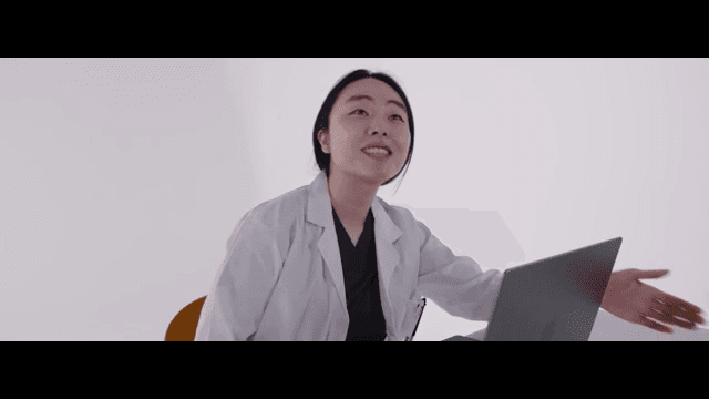 미소를 지으며 누군가에게 자리를 안내하는 의사