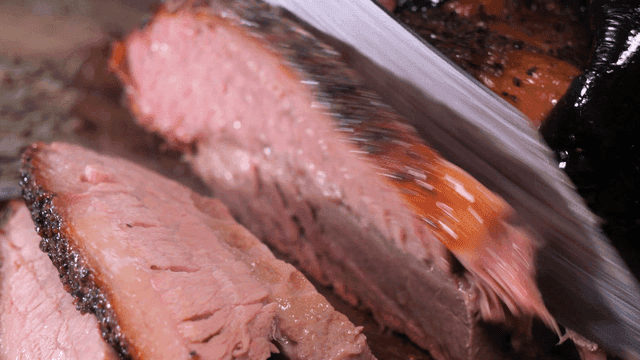 Juicy brisket being sliced with a knife
