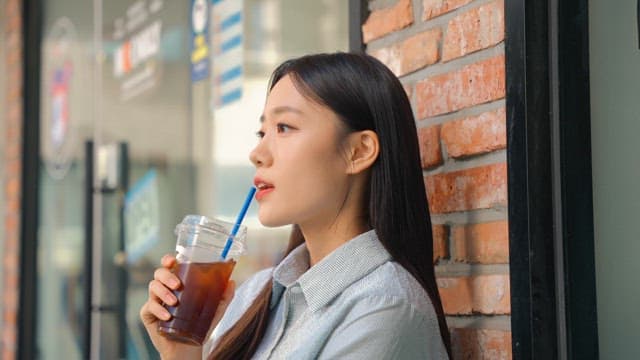 커피를 마시며 휴식을 취하고 있는 젊은 여성