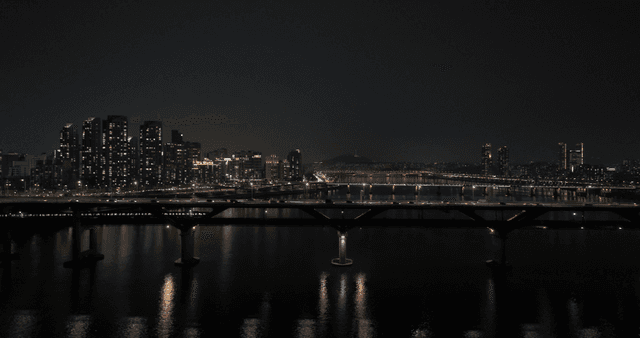 Cars and subways running on river against city backdrop