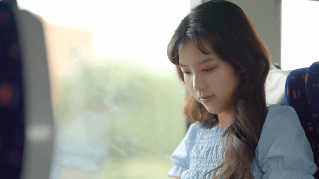 이어폰을 끼는 기차 안의 젊은 여성