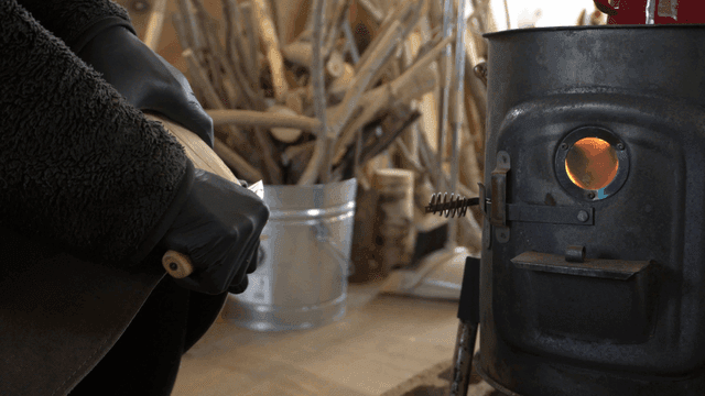 따뜻한 난로 옆에서 나무 조각하는 목수