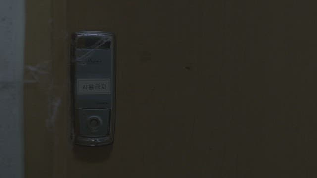 잠겨있는 도어락을 살피는 사람