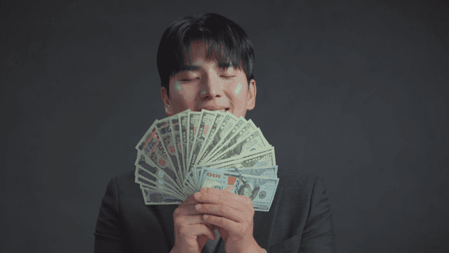 Man smelling money with a satisfied expression