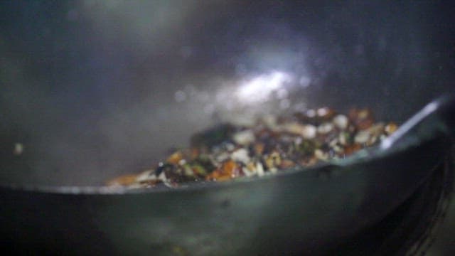 Stir-frying vegetables with black bean sauce in a hot wok