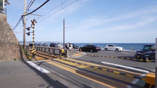 맑은 날 바다 근처 건널목을 지나가는 기차