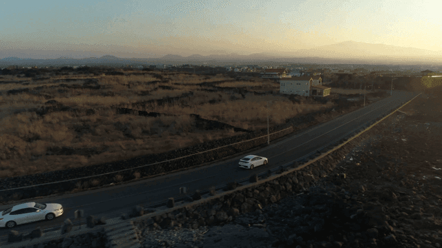 Car driving on a rural road at sunset