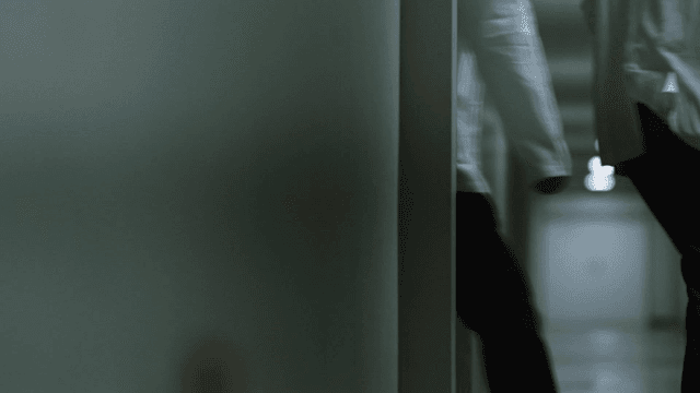 Man dragging boxes of records through dark hallway