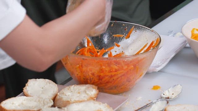 크림 치즈가 발린 바게트 위에 양념된 당근 올리기