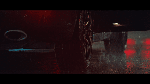 Person getting into car parked on rainy night