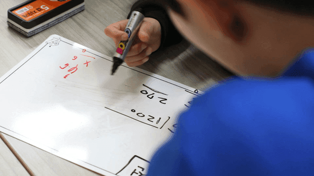 Students solving math problems on a board