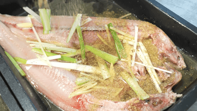 Fish sprinkled with seasoning and vegetables