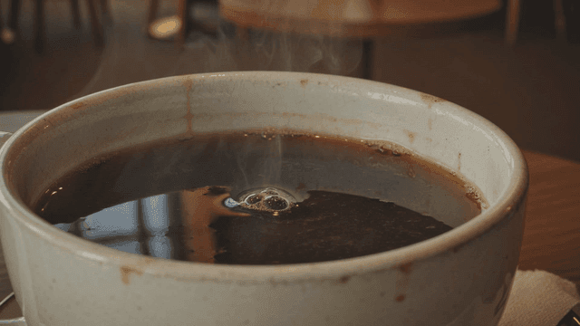 Steaming cup of coffee on a table