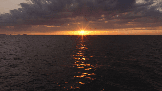 Sunset over the calm ocean horizon