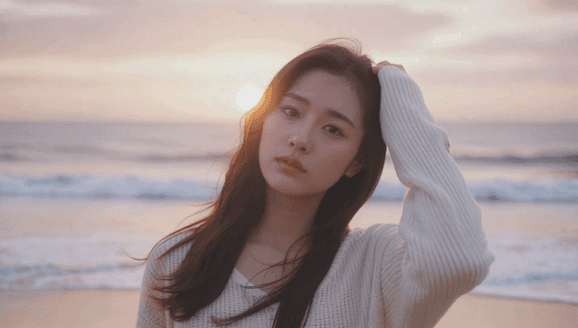 일몰시간 모래해변에 서있는 젊은 여성