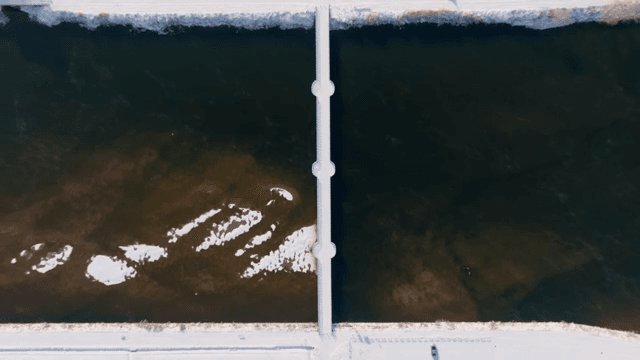 고요한 강 위의 눈 덮인 다리