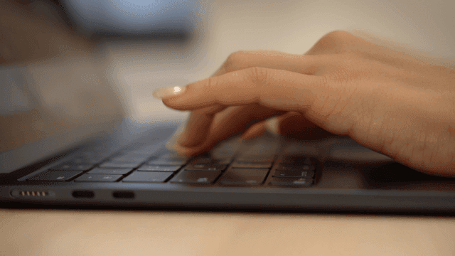 Hands typing on laptop