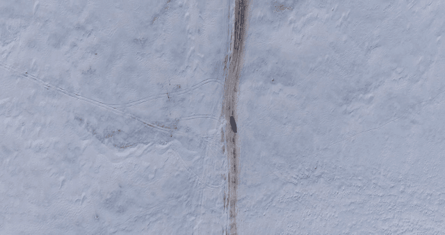 Vehicle traveling across a snowy landscape