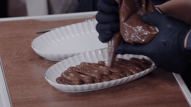 Chocolate mousse being piped onto a plate