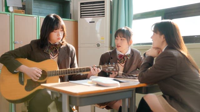 Student playing guitar in a classroom