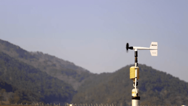 산을 배경으로 한 풍향계