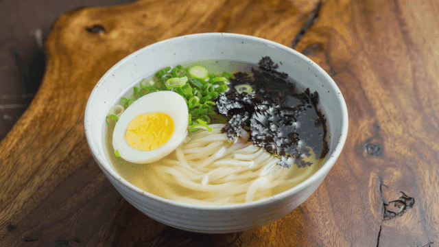 Janchi-guksu topped with boiled egg and seaweed flakes