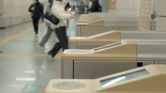 People passing through subway turnstiles