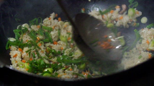 Vegetable fried rice being cooked in a wok