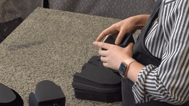 Person assembling black paper boxes
