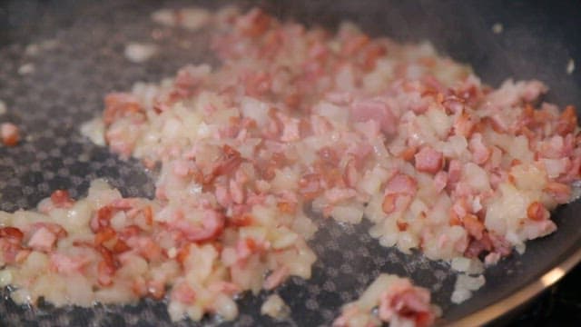 Stir-frying minced bacon and onion with soy sauce