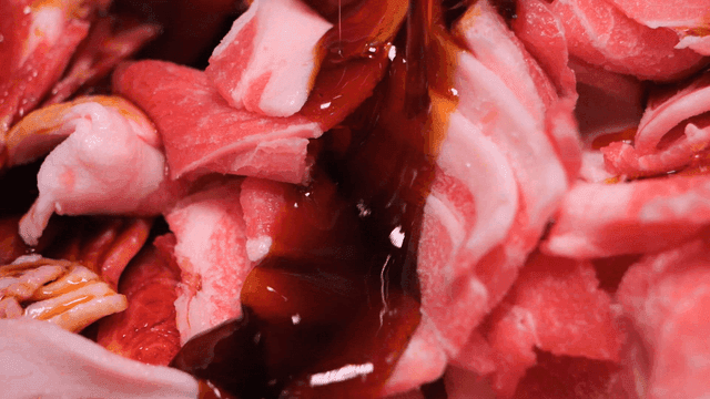 Raw meat being marinated with sauce