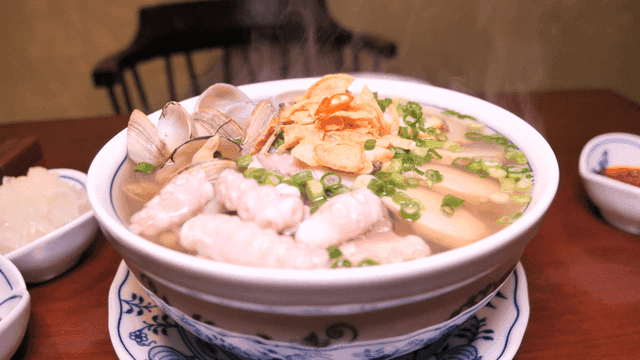 Steaming hot seafood rice noodles on table