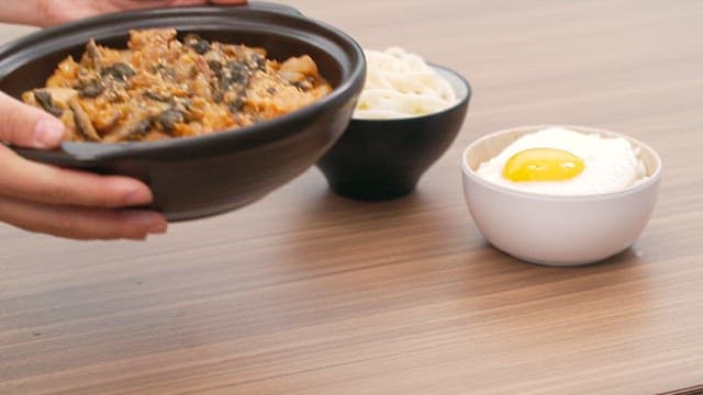 Table topped with warm dried radish greens and pork belly stew and fried egg