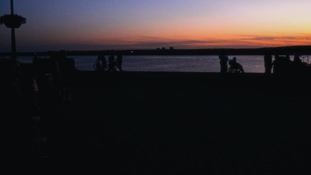 해질녘 강가에서 평화로운 저녁을 즐기는 사람들