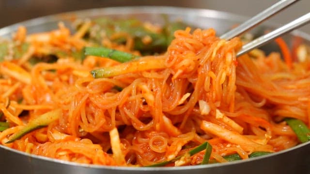 신선한 채소가 들어간 먹음직스러운 비빔쫄면 한 젓가락